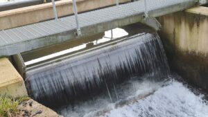 tilting weir with water going over the top